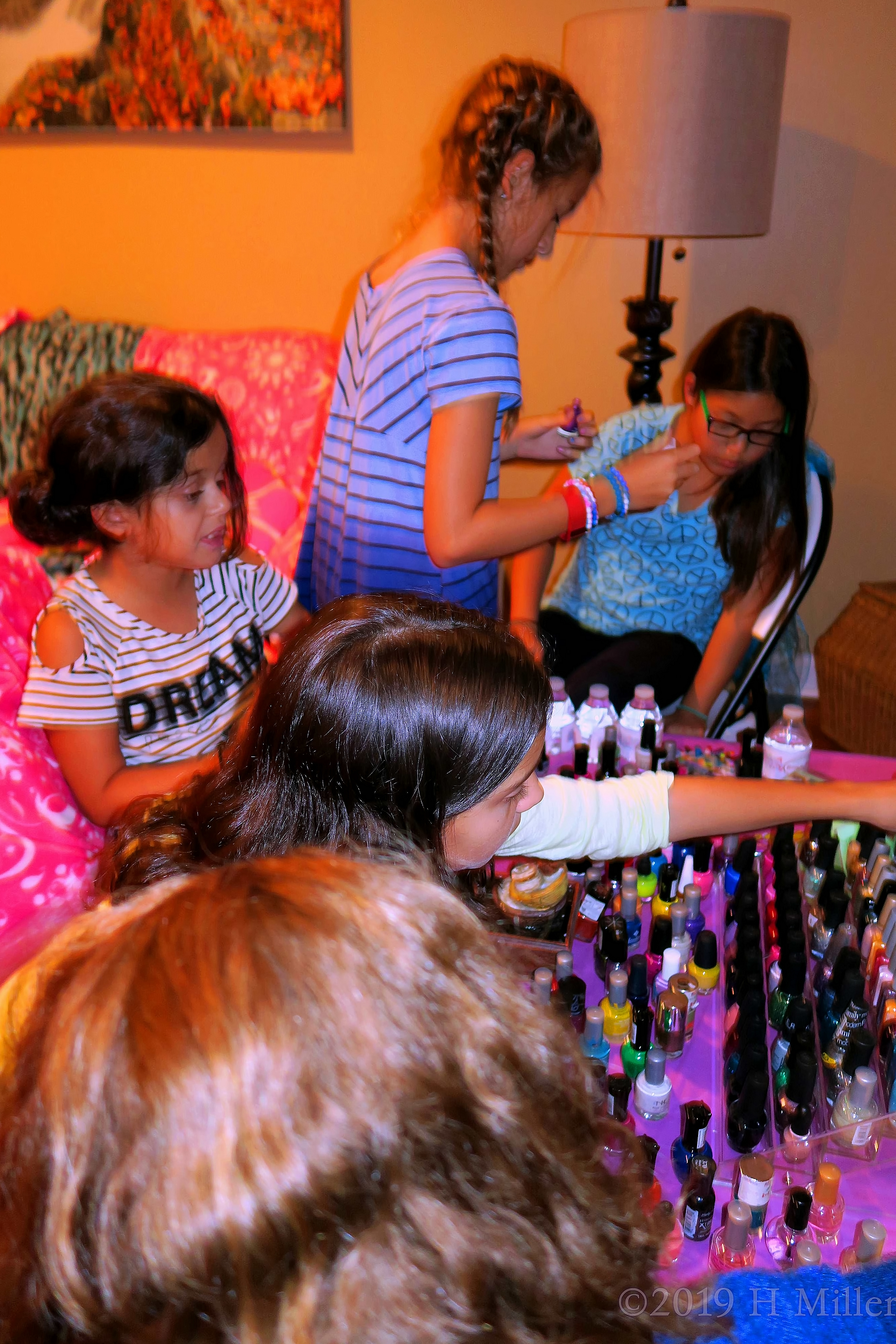 Party Guests Having Fun Choosing Their Color Polishes From The Nail Art Station