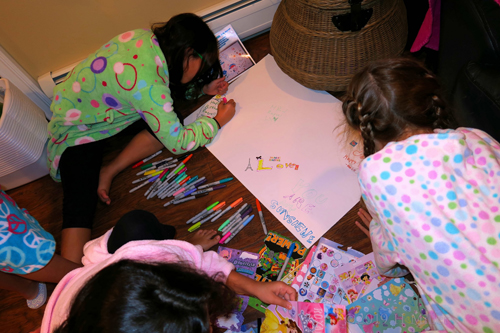 Party Guests Decorating The Spa Birthday Card With Sweet Messages