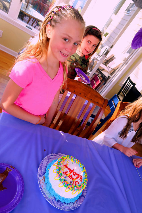The Birthday Girl Standing Before Her Cake.
