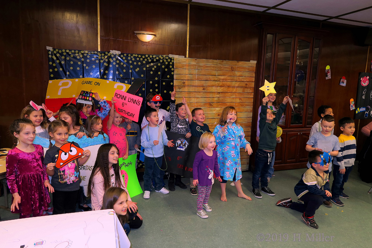 Party Guests Having Fun Posing For The Camera And Showing Off Their Kids Crafts 