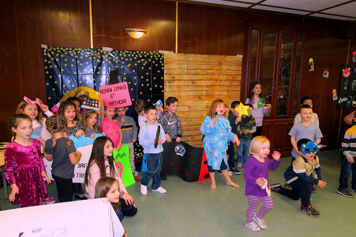 Party Guests Hold Up Banners And Wish Happy Birthday To RonniLynn 