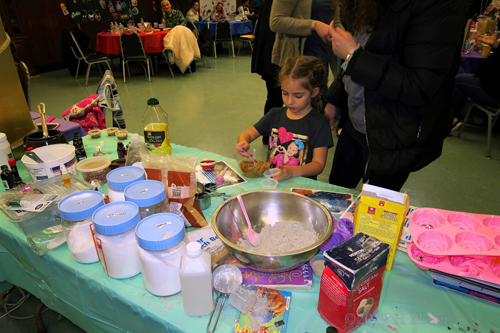 Close Up Of Kids Craft Station With Party Guest Getting Her Crafts Made