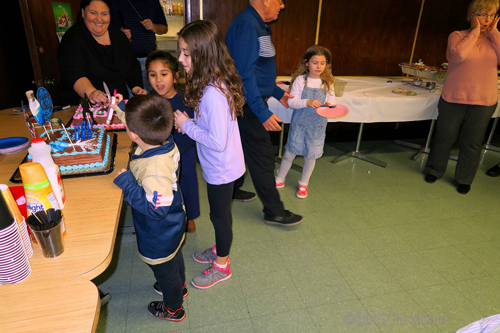 Party Guests Helping To Decorate The Birthday Cake Party Guests Helping To Decorate The Birthday Cake