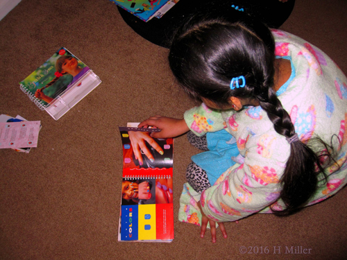 Perusing A Nail Art Design Book At Sanjana's Spa Party. Perusing A Nail Art Design Book At Sanjana's Spa Party.