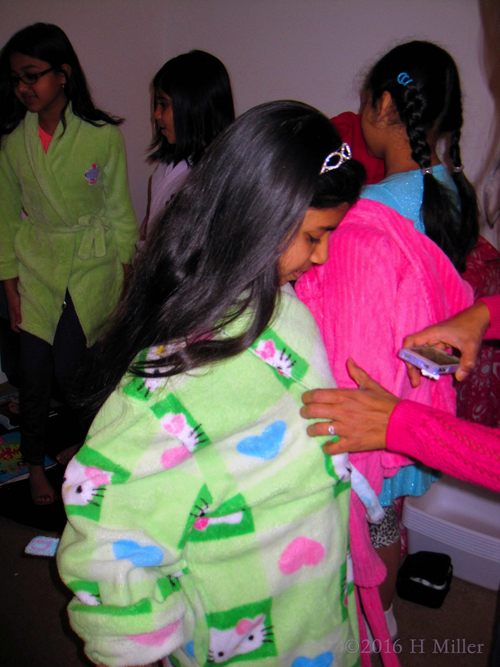 Receiving Some Help Putting On Her Spa Party Robe. Receiving Some Help Putting On Her Spa Party Robe.