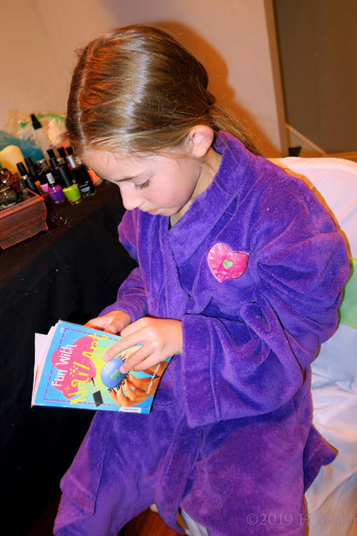 She Is Reading The Instructions On Nail Designs. She Is Reading The Instructions On Nail Designs.