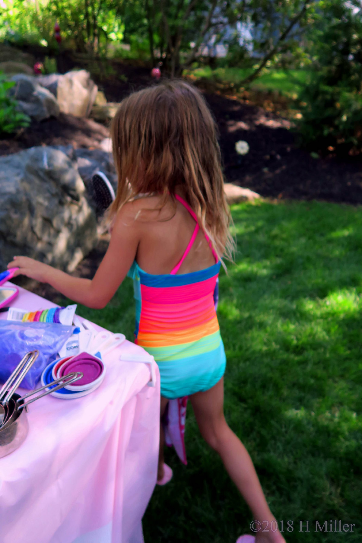 Rainbow Swimsuit Party Guest Playing With Hair Styling Tools 1