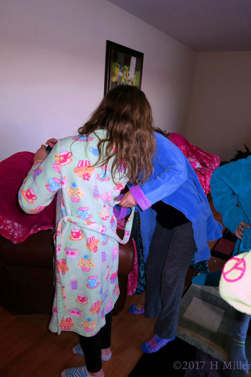 Party Guests Helping Each Other Out With Their Spa Robes Party Guests Helping Each Other Out With Their Spa Robes